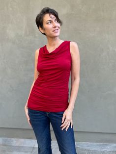 women's plant based rayon jersey red top with ruching on sides and slight cowl neck #color_red Ruched Draped Top In Elastane, Ruched Draped Elastane Top, Ruched Top With Stretch And Asymmetrical Neckline, Stretch Top With Ruched Asymmetrical Neckline, Asymmetrical Neckline Top With Ruched Stretch, Asymmetrical Neckline Top With Ruched Detail, Versatile Fitted Draped Top, Chic Draped Elastane Tops, Fitted Ruched Tops For Layering