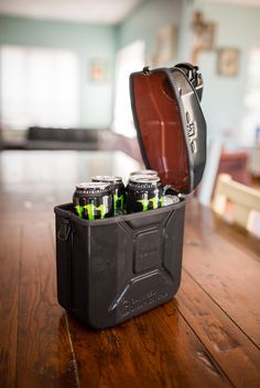 a black case with four cans in it sitting on a wooden table