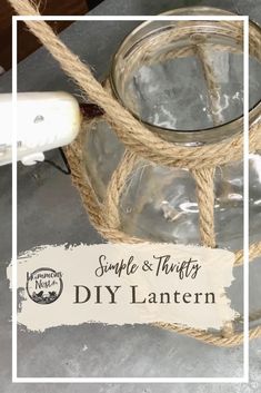 an empty glass jar with rope hanging from it's side and the label saying simple & thrifty diy lantern