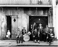 an old black and white photo of men with musical instruments in front of a building