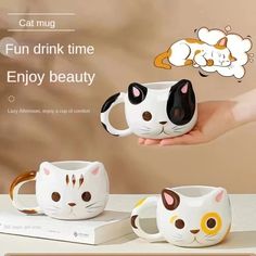 a person holding two coffee mugs with cats on them and the caption cat mug fun drink time enjoy beauty