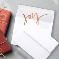 two wrapped presents are next to an envelope with the word xox written on it