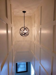 a light hanging from the ceiling in a hallway