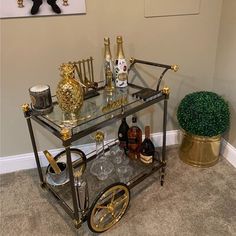 a bar cart with bottles and glasses on it