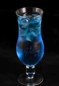 a glass filled with blue liquid on top of a black table next to the words, the blue lagoon 2oz vodka 1oz blue curacco 3 4 042 lemonade