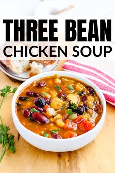 three bean chicken soup in a white bowl on a wooden table with red and white striped napkin