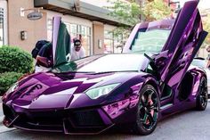 a man taking a photo of a purple sports car