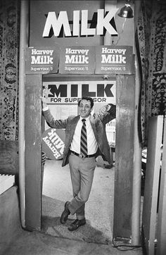 a man in a suit and tie is standing at the entrance to a milk machine