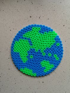 a blue and green beaded earth sitting on top of a table