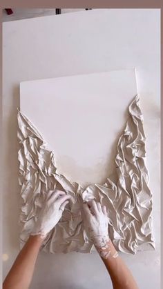 someone is working on a piece of paper that looks like ruffles and folds