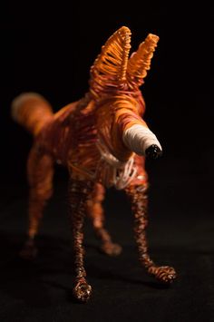 a toy dog made out of plastic on a black background