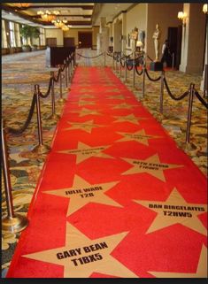 a red carpet with white stars and black writing on it in an airport lobby area