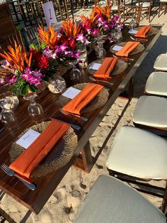 an outdoor table set up with place settings and flowers on the tables for guests to sit at