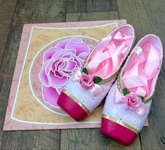 pair of pink and gold shoes sitting on top of a wooden floor next to a rug