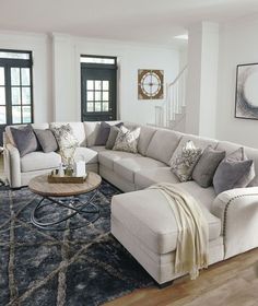 a living room filled with furniture and a large rug on top of a hard wood floor