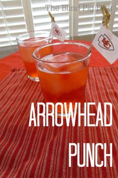 two glasses filled with liquid sitting on top of a red and white striped table cloth