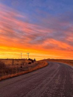 an empty road in the middle of nowhere during sunset or sunrise with clouds and blue sky