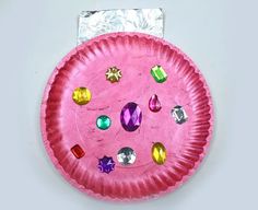 a pink paper plate with jewels on it