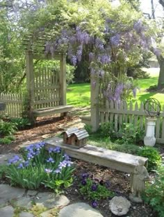 an outdoor garden with stone benches and purple flowers