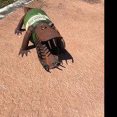 a green and white machine sitting on top of a dirt field