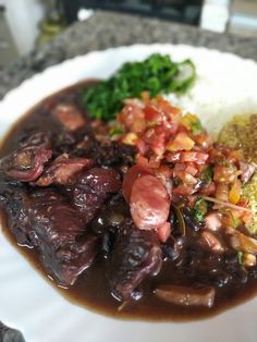 a white plate topped with meat, rice and broccoli covered in gravy