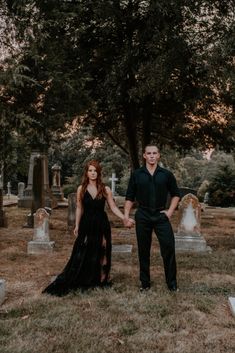 a man and woman holding hands in front of headstones