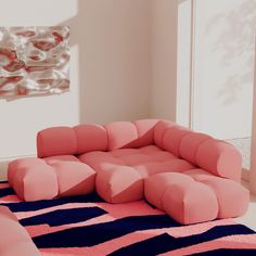 a pink couch sitting on top of a blue rug