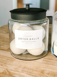 a jar filled with dryer balls sitting on top of a wooden table