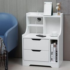 a white bookcase with two drawers next to a blue chair