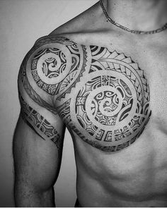 a black and white photo of a man's chest with an intricate tattoo design on it