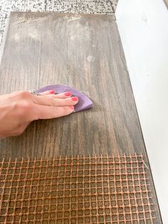 a woman is cleaning the floor with a cloth on top of an old wooden table