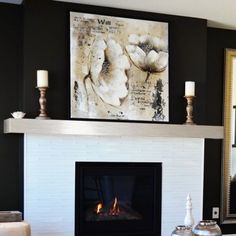 a living room with a fire place and pictures on the wall above it's mantle