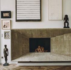 a living room with a fire place in the center and various pictures on the wall