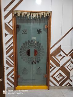 a glass door with the word omen written on it is in front of a patterned wall