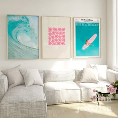 a living room filled with white furniture and paintings on the wall above it's couch