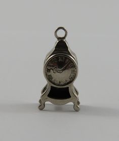 a small silver clock sitting on top of a table