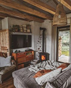 a living room filled with furniture and a fire place next to a window covered in blankets