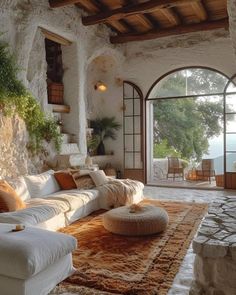 a living room filled with lots of white furniture and large open doors leading to an outside patio