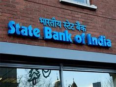 state bank of india sign on the side of a brick building with glass doors and windows