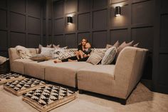 a woman sitting on top of a couch next to pillows