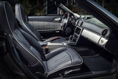 the interior of a sports car with black leather and chrome trims is seen in this image