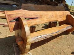 a wooden bench sitting on top of a pile of wood planks in the dirt