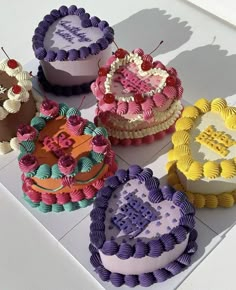 six decorated cakes sitting on top of a white table