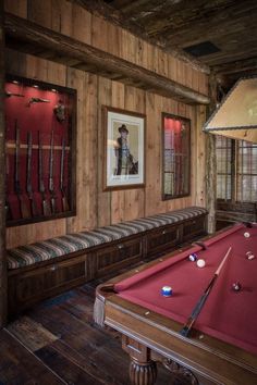 a pool table in a room with wooden walls