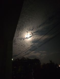 the full moon is shining brightly in the night sky above power lines and telephone poles