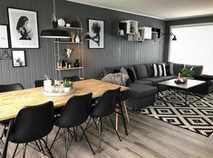 a living room filled with furniture and pictures on the wall next to a wooden table