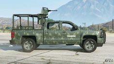 a green camo truck parked in front of a mountain