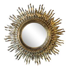 a gold sun mirror hanging on the wall