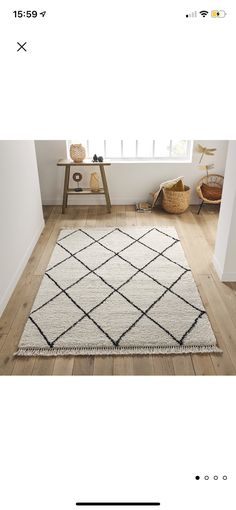 a white and black area rug on a wooden floor