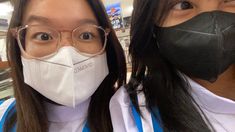 two women wearing face masks and glasses in a store with the words commo written on them